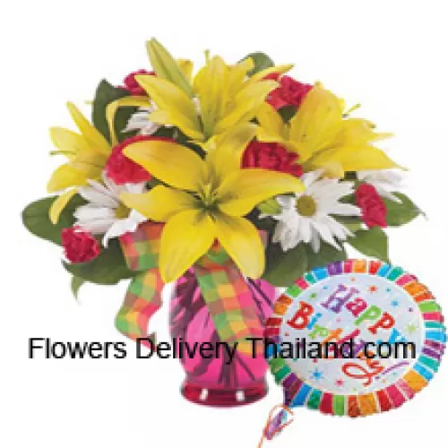 Oeillets rouges, lys jaunes et gerberas blancs dans un vase en verre accompagnés d'un ballon d'hélium "anniversaire"