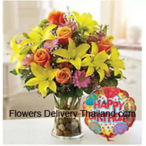 Tulipes jaunes, roses oranges et autres fleurs assorties parfaitement arrangées dans un vase en verre accompagnées d'un ballon d'anniversaire