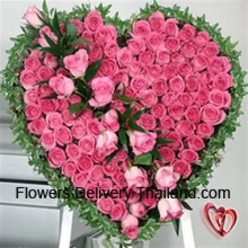 Un bel arrangement en forme de cœur de 100 roses roses