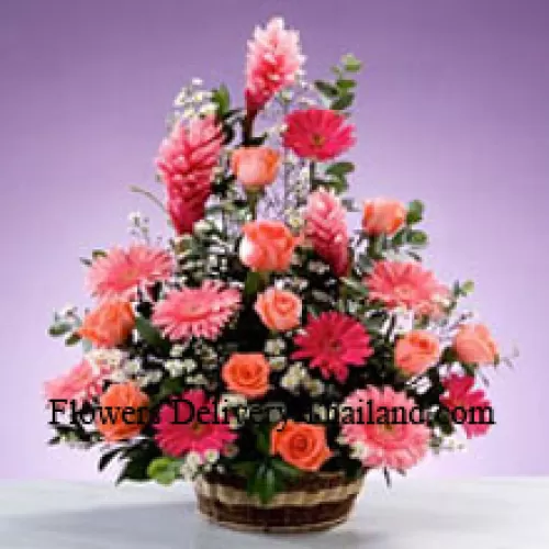 Panier de fleurs assorties comprenant des gerberas, des roses et des garnitures saisonnières