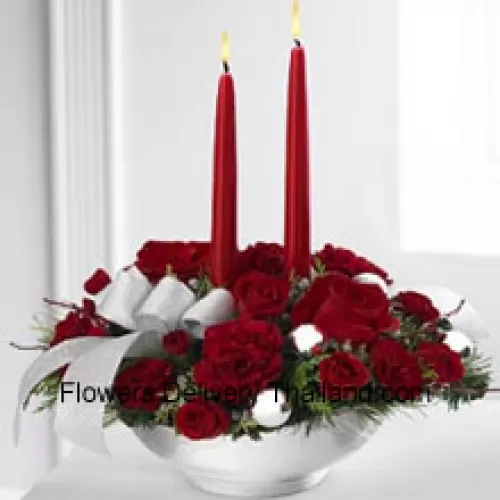 Our Holiday Elegance Centerpiece will add that special spark to their seasonal celebration with its vibrant array of crimson blooms! Red roses, carnations and spray roses sit amongst holiday greens in a posh ceramic silver container adorned with a beautiful silver ribbon accent and two taper candles to bring a holiday glow of warmth and peace to their table. (Please Note That We Reserve The Right To Substitute Any Product With A Suitable Product Of Equal Value In Case Of Non-Availability Of A Certain Product)